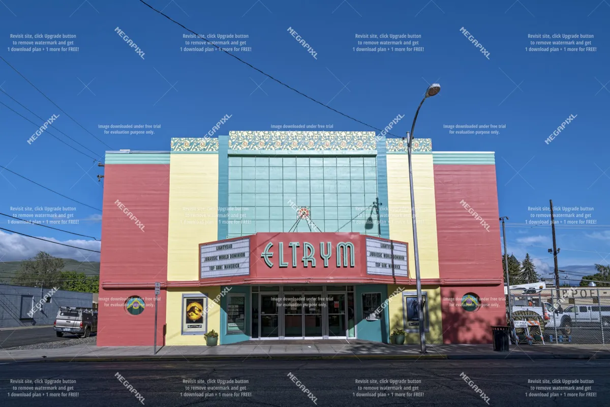A nostalgic exterior shot of the Eltrym Theatre, with its colorful marquee and classic entrance doors. The bright facade and bold signage evoke a sense of community, entertainment, and vintage charm in Baker City’s historic district.