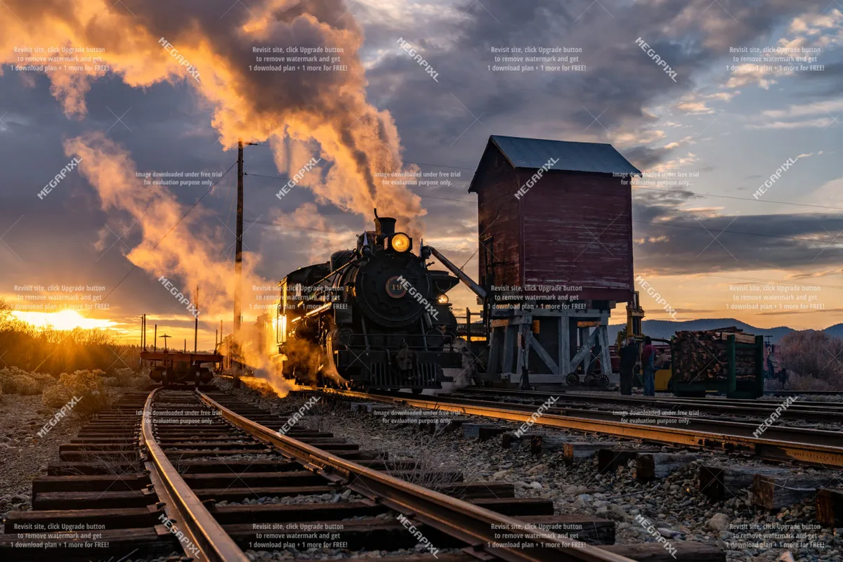 A vintage steam locomotive sits on the tracks at sunset, with a water tower and old-fashioned railroad station visible in the background. The warm glow of the setting sun adds a nostalgic and adventurous air, inviting exploration of Baker City's historic attractions.